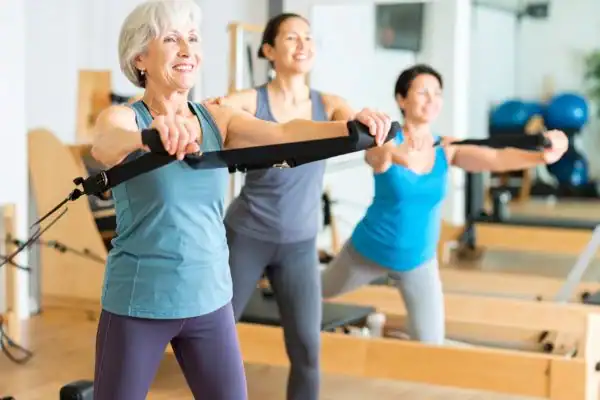 Toning Arms After 60: Empowering Womens Fitness Through Effective Weight Training 2 older woman doing weight training York and resistance in the gym to tone upper arms