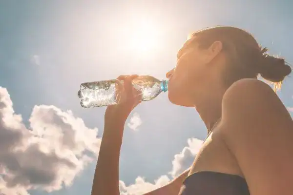 Hydration: The Secret Ingredient for a Toned Stomach and Enhanced Fitness 3 Image of woman drinking water to hydrate York after run.