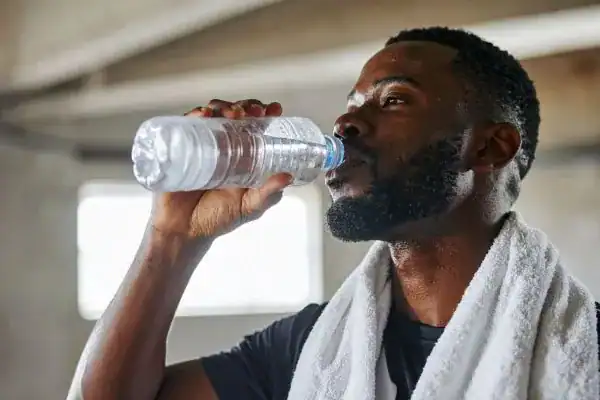 Hydration: The Secret Ingredient for a Toned Stomach and Enhanced Fitness 1 Image of man drinking water to improve hydration York after work out.